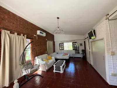 a living room with a white couch and a brick wall at El mirador de estrellas in Santa Rosa de Calamuchita