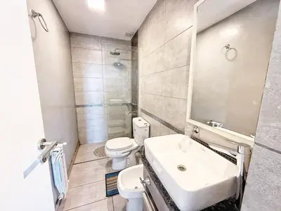 a bathroom with a sink and a toilet and a mirror at Stefano IV in Villa Carlos Paz