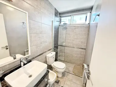 a bathroom with a toilet and a sink and a shower at Stefano IV in Villa Carlos Paz