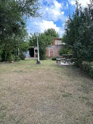 a park with two picnic tables and a street light at El Roble in Merlo