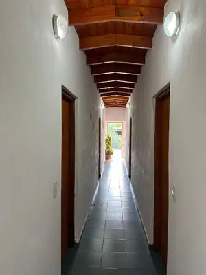 a hallway with white walls and a wooden ceiling at El Roble in Merlo