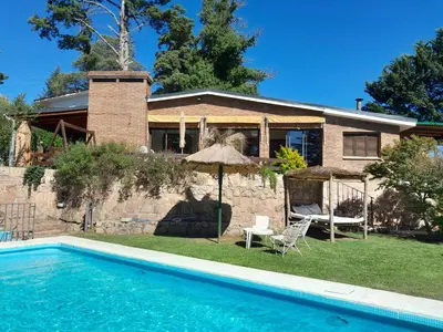 a house with a swimming pool in front of a house at Casa frente al rio icho cruz 10 personas ideal varias parejas o familias in Villa Icho Cruz