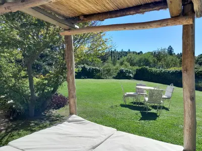 a patio with a table and chairs in a yard at Casa frente al rio icho cruz 10 personas ideal varias parejas o familias in Villa Icho Cruz