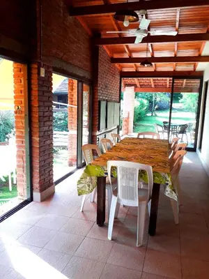 a wooden table and chairs on a patio at Casa frente al rio icho cruz 10 personas ideal varias parejas o familias in Villa Icho Cruz