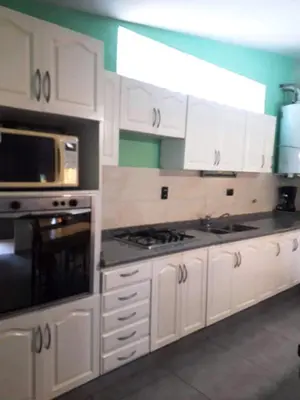 a kitchen with white cabinets and a stove top oven at Casa frente al rio icho cruz 10 personas ideal varias parejas o familias in Villa Icho Cruz
