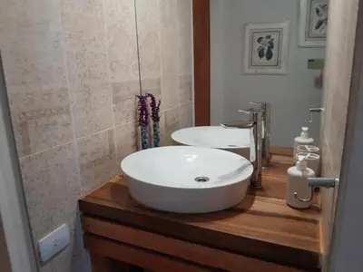 a bathroom with a white sink and two mirrors at Casa frente al rio icho cruz 10 personas ideal varias parejas o familias in Villa Icho Cruz