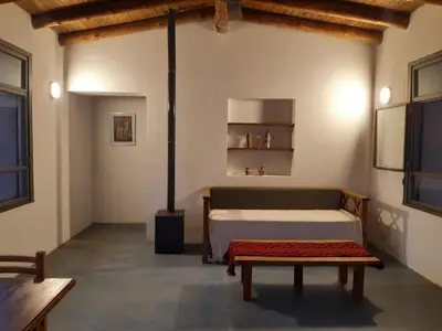a bedroom with a bed and a bench in a room at La Roja y Barro tal vez in Los Molles