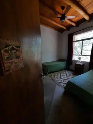 a room with a bed and a door with a window at La Roja y Barro tal vez in Los Molles