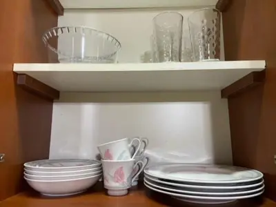 a shelf with plates and cups and dishes in a refrigerator at Merlo2 in Merlo