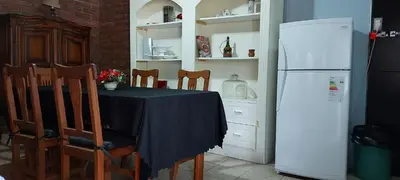 a kitchen with a table and a white refrigerator at Merlo2 in Merlo