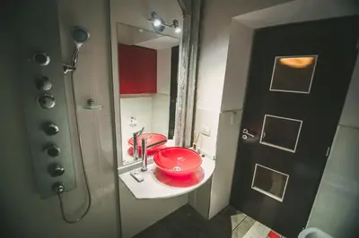 a bathroom with a red sink and a mirror at casa del alto categoria vista plena lago pileta in Villa Carlos Paz