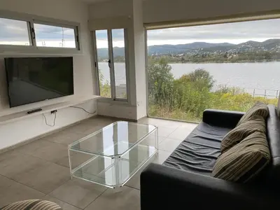 a living room with a couch and a glass coffee table at casa del alto categoria vista plena lago pileta in Villa Carlos Paz