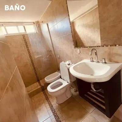 a bathroom with a sink and a toilet and a mirror at casa del alto categoria vista plena lago pileta in Villa Carlos Paz
