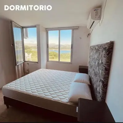 a bedroom with a large bed with two windows at casa del alto categoria vista plena lago pileta in Villa Carlos Paz