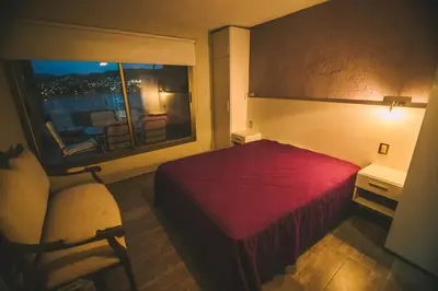 a hotel room with a red bed and a window at casa del alto categoria vista plena lago pileta in Villa Carlos Paz