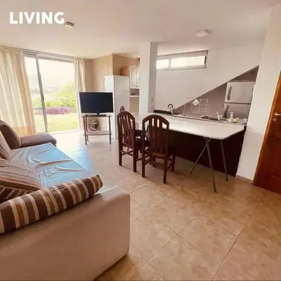 a kitchen and living room with a couch and a table at casa del alto categoria vista plena lago pileta in Villa Carlos Paz