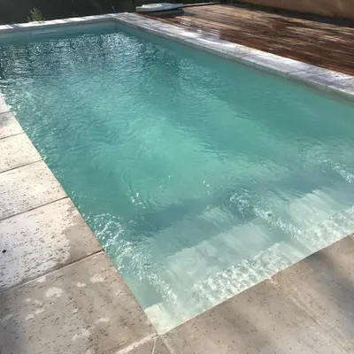 a swimming pool with blue water in a yard at Cabañas San Urbano 1 in Villa Yacanto