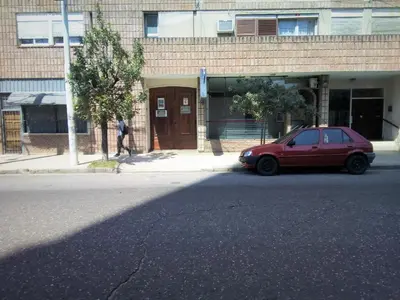 a red car parked in front of a building at Amplio 2 Dormitorios en Cofico in Cordoba