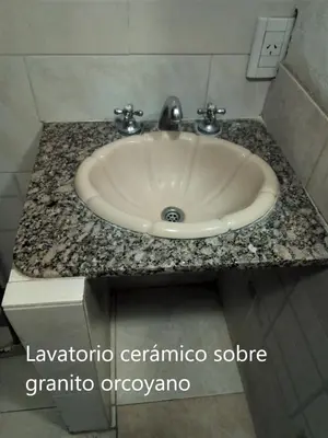 a bathroom sink with a granite counter top at Amplio 2 Dormitorios en Cofico in Cordoba