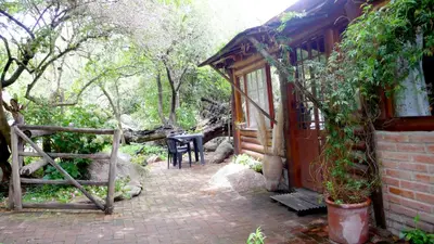 a small house with a table and a chair outside at Cabañas Entrelomas in Nono