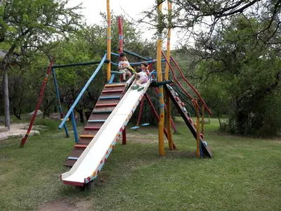 a group of children playing on a slide at a playground at Cabañas Entrelomas in Nono