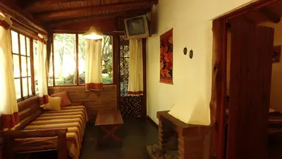 a living room with a couch and a tv at Cabañas Entrelomas in Nono