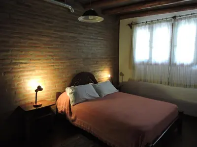 a bedroom with a bed and a brick wall at Cabañas Entrelomas in Nono
