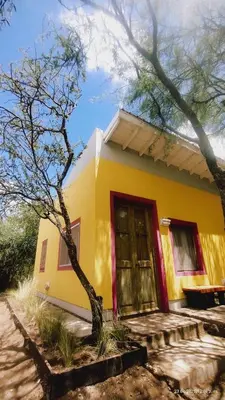 a small yellow house with a red door at apartamento VINTAGE LU in Merlo