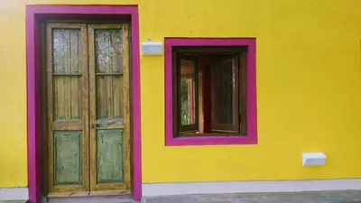 a yellow building with two doors and windows at apartamento VINTAGE LU in Merlo