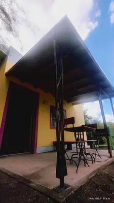 a building with a table and chairs under a roof at apartamento VINTAGE LU in Merlo