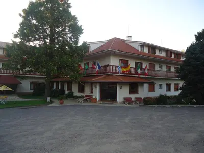 a large white building with flags on the balconies at Hotel Edelweiss in Villa General Belgrano