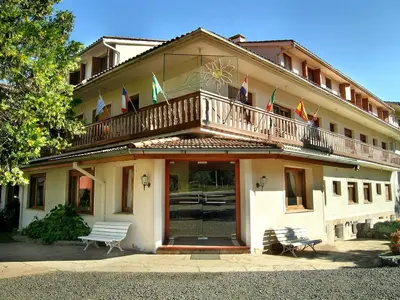 a building with a balcony with flags on it at Hotel Edelweiss in Villa General Belgrano