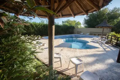 a swimming pool with chairs and a gazebo at Cabañas El Vallecito in Villa del Dique