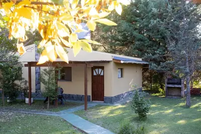 a small house with a door in a yard at Cabañas El Vallecito in Villa del Dique