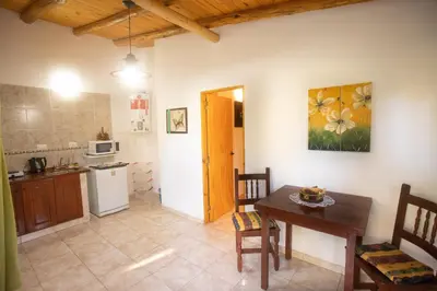 a kitchen and dining room with a table and a table and a table at Cabañas El Vallecito in Villa del Dique