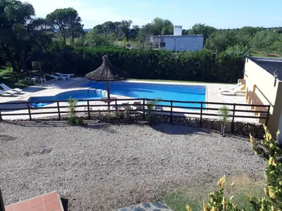 a swimming pool with a fence and an umbrella at Cabañas El Vallecito in Villa del Dique