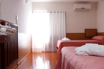 a hotel room with two beds and a window at Hotel Menossi in Río Cuarto