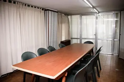 a conference room with a long wooden table and chairs at Hotel Menossi in Río Cuarto