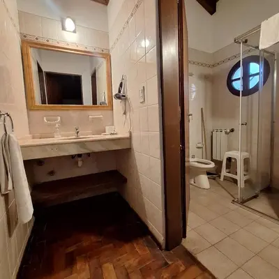 a bathroom with a sink and a shower and a toilet at Hostal La Merced in Villa General Belgrano