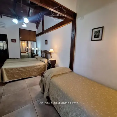 a hotel room with two beds in a room at Hostal La Merced in Villa General Belgrano