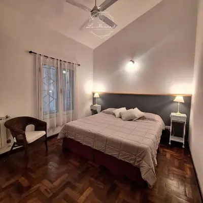 a bedroom with a bed and a ceiling fan at Hostal La Merced in Villa General Belgrano