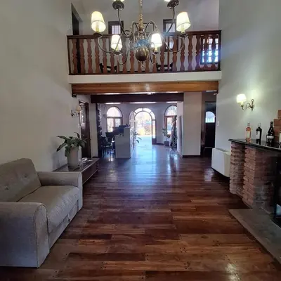 a living room with a couch and a chandelier at Hostal La Merced in Villa General Belgrano
