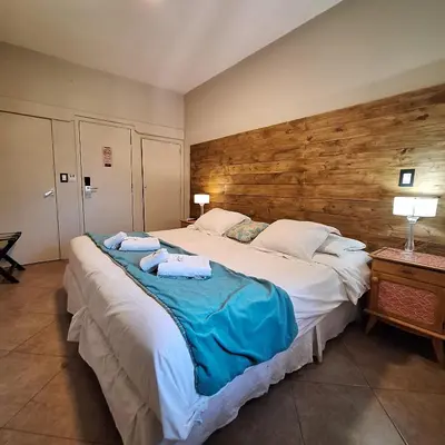 a bedroom with a large bed with towels on it at Hotel Antiguo Camino in Villa General Belgrano