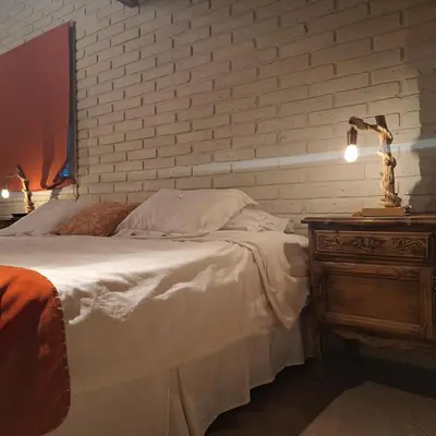 a bedroom with a bed and a brick wall at Hotel Antiguo Camino in Villa General Belgrano