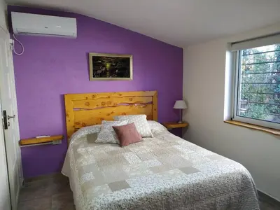 a bedroom with a bed with a purple wall at Rincón Sereno in Villa General Belgrano