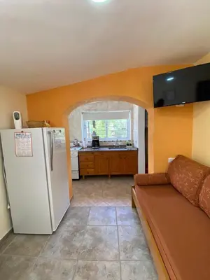 a living room with a white refrigerator and a kitchen at Rincón Sereno in Villa General Belgrano