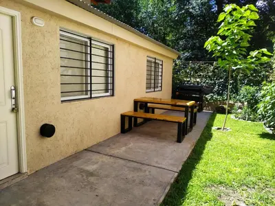 a picnic table and bench next to a house at Rincón Sereno in Villa General Belgrano