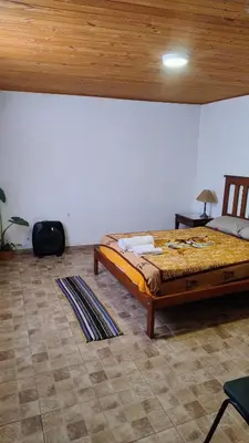 a bedroom with a large bed and a wooden ceiling at Mirador Sierras in Alta Gracia