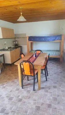 a wooden table and chairs in a room with a kitchen at Mirador Sierras in Alta Gracia