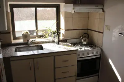 a kitchen with a sink and a stove and a window at DEPTO EN VILLA GRAL BELGRANO in Villa General Belgrano